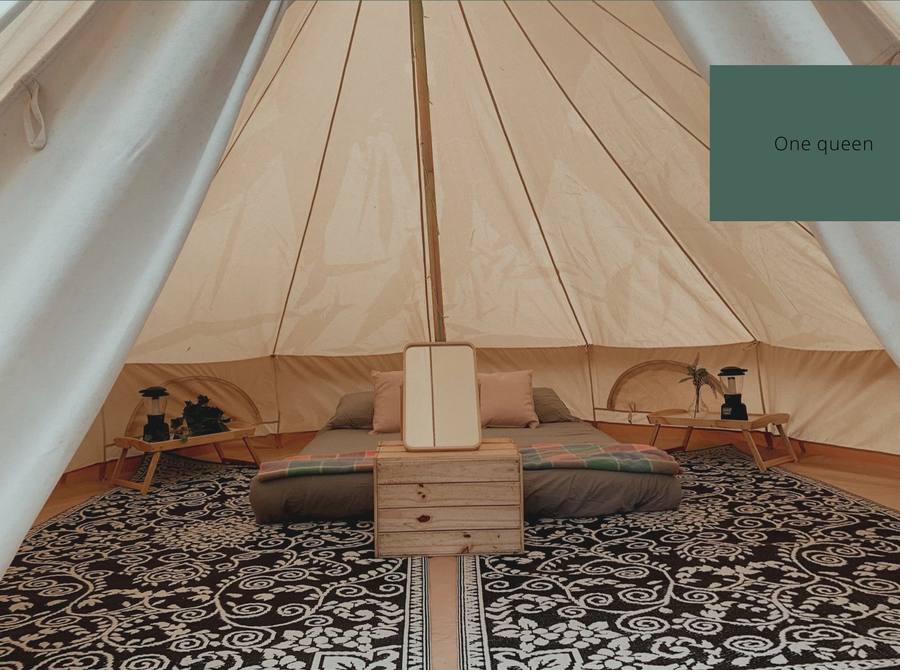 Glamping tent interior with queen bed